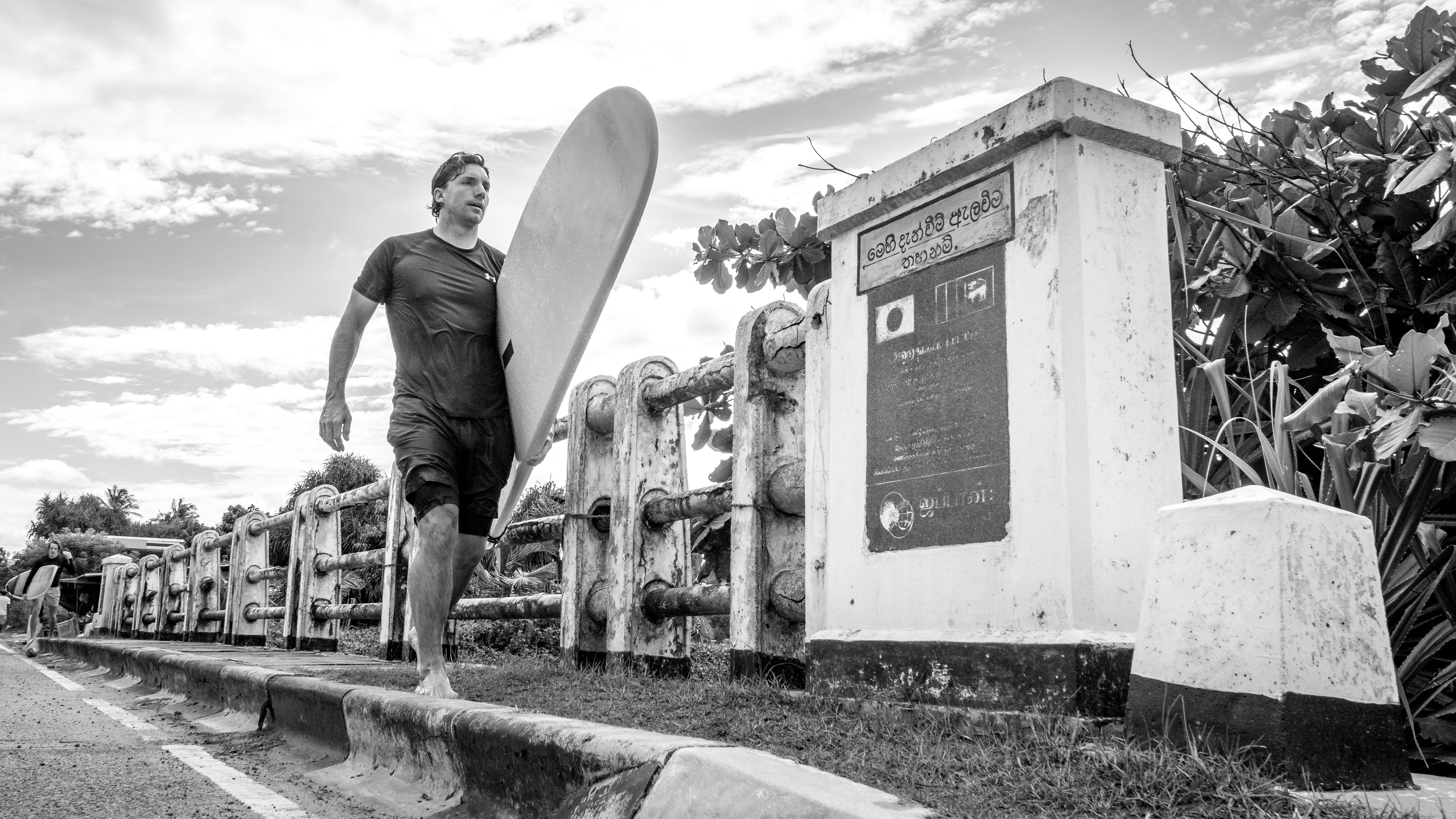 Photo of a surfer guy on a bridge in Sri Lanka